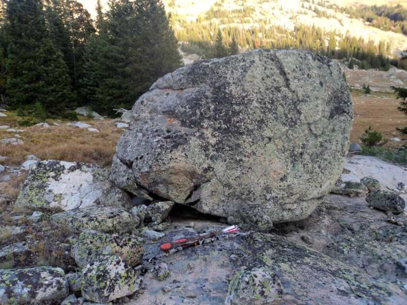 TAKE THE SHOT: A traditional bowhunter is offered a mid-range shot at a moving bull elk. Should he take the shot? Rock with bloody arrow in front