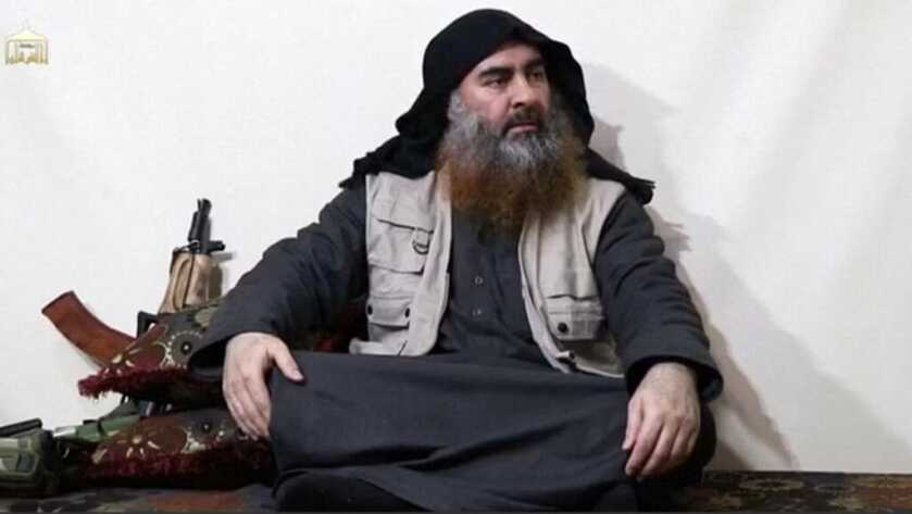 abu bakr al-baghdadi sitting with a rifle next to him
