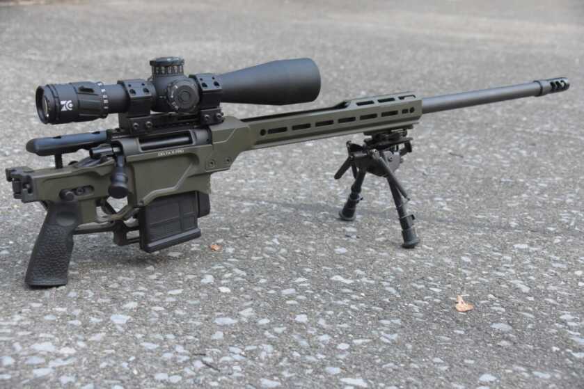 The Daniel Defense Delta 5 Pro has its stock folded and is laying on a concrete pad. 