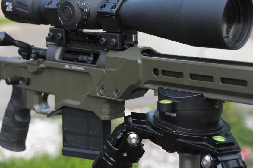 A Green Daniel Defense Delta 5 Pro is mounted to a tripod using the ARCA rail.