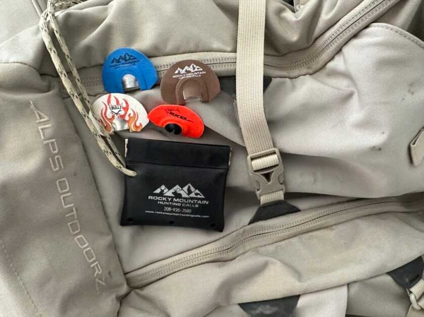 5 Pieces of Backcountry Elk Gear You Don't Want To Forget Rocky Mountain Hunting Calls with carrying pouch and grey gear bag