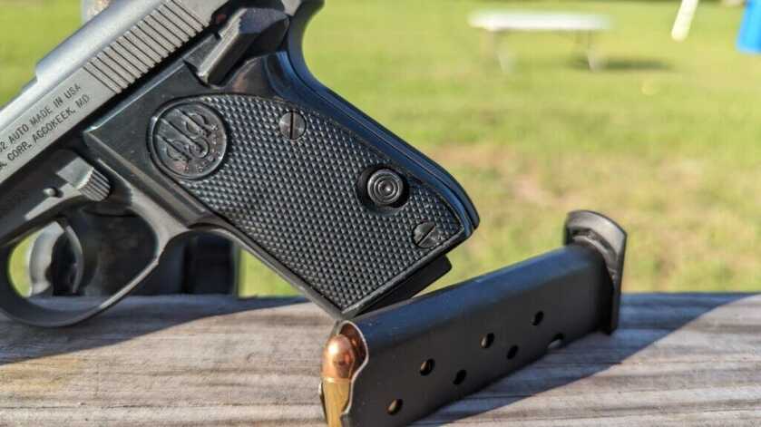 Beretta Tomcat and loaded magazine propped on wood