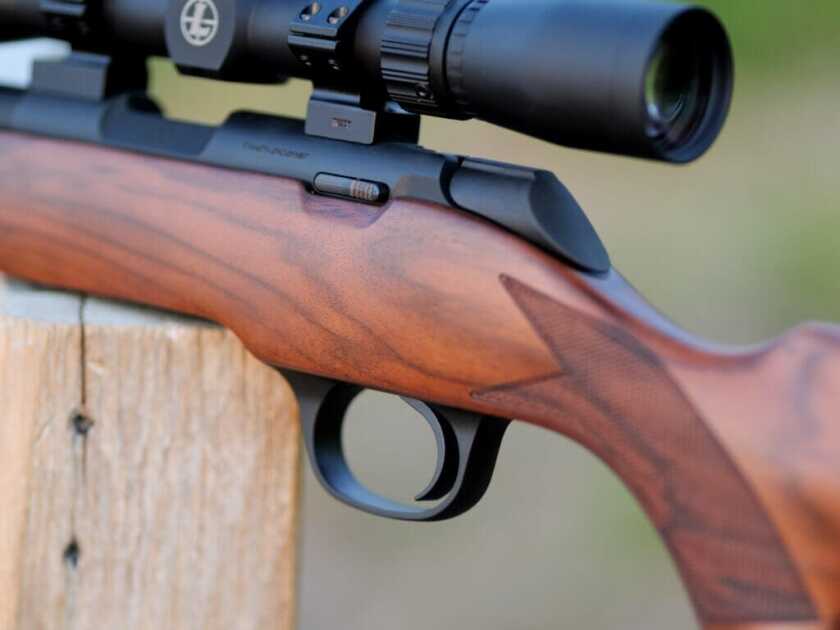 Close up of the trigger on the 2020 Rimfire Rifle with a walnut stock.