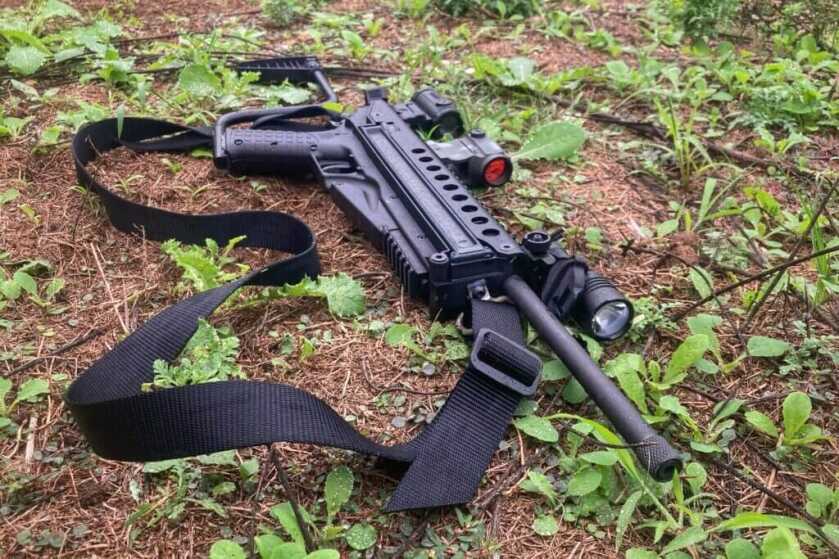 KelTec R50 laying on damp grass. threaded muzzle.