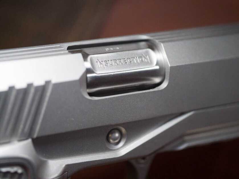 Close up view of the Insurrection's ejection port. "Insurrection" is inscribed on the right side of the barrel, and "9mm" is inscribed on the top.