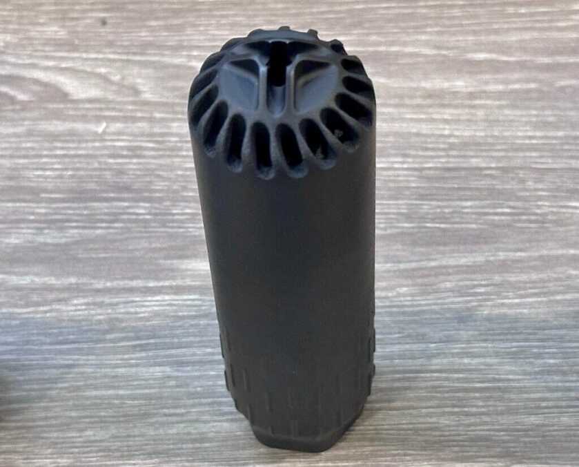 A suppressor is on display in a glass cabinet.