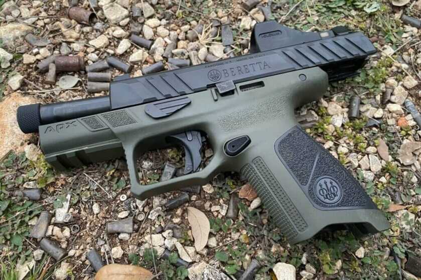 Beretta handgun lying on gravelly ground with old bullet brass scattered around it