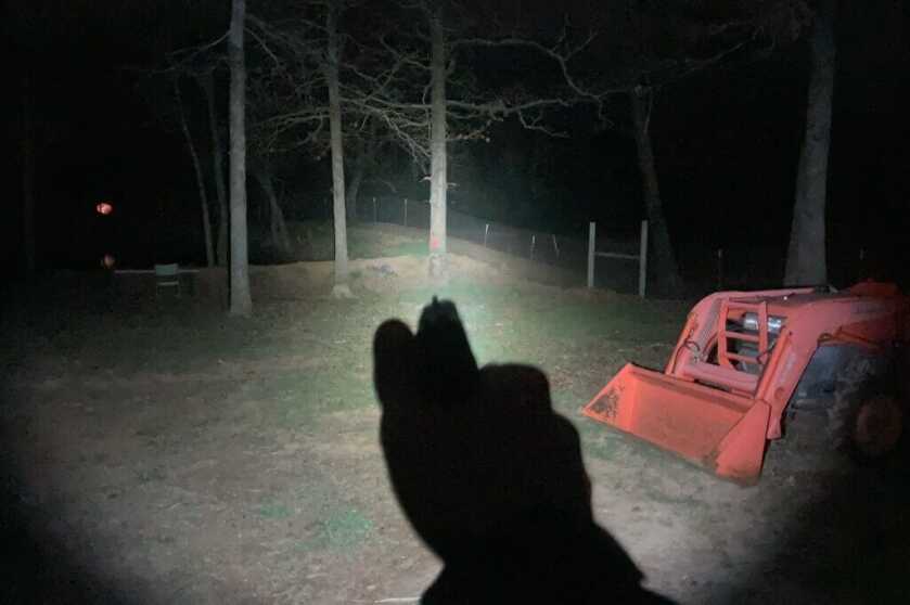 Light on pistol pointing out into darkness