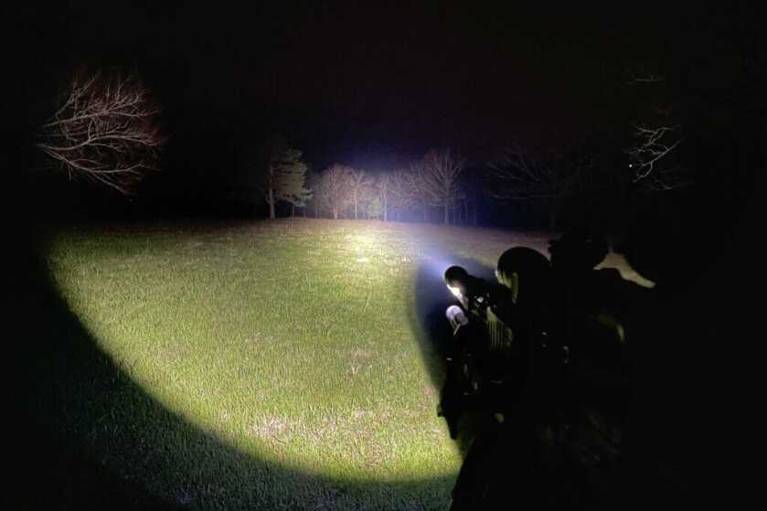 Strong light beam from end of rifle at the dead of night