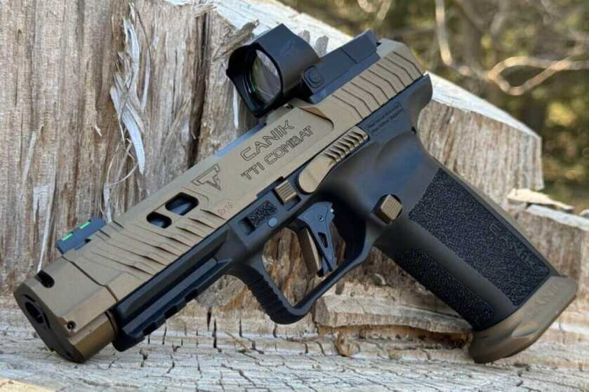 Serrated slide on the CANiK TTI Combat pistol sitting on a wood stump