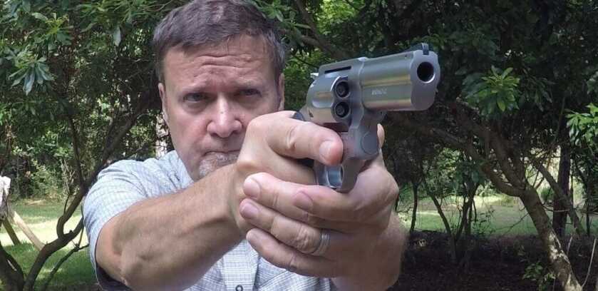 Man aiming down barrel of Rossi RP63