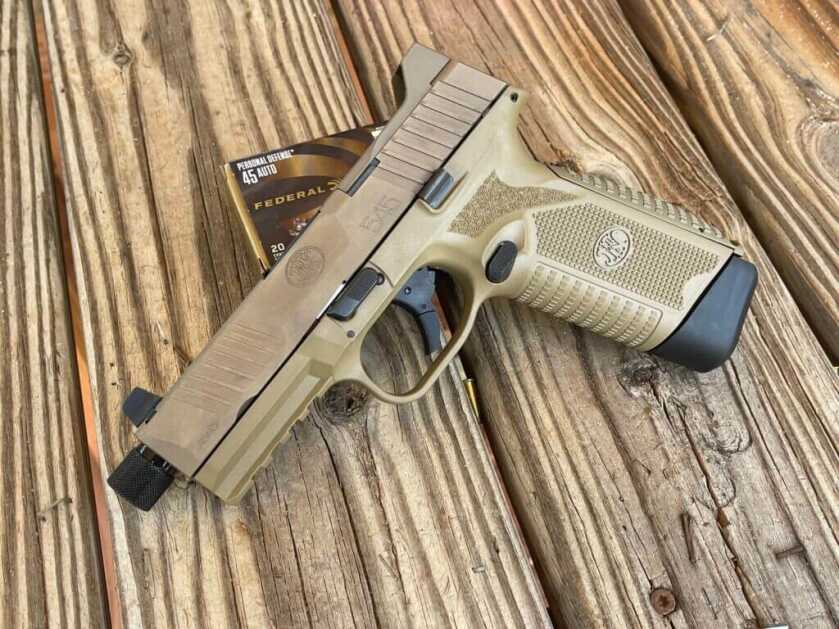 Gold colored handgun on wooden table with Federal Ammo