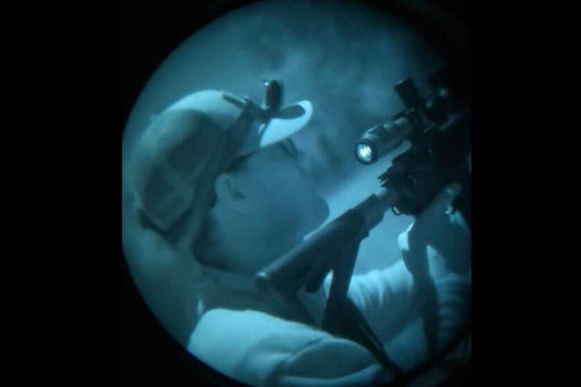 screen shot of hunter with rifle through night vision