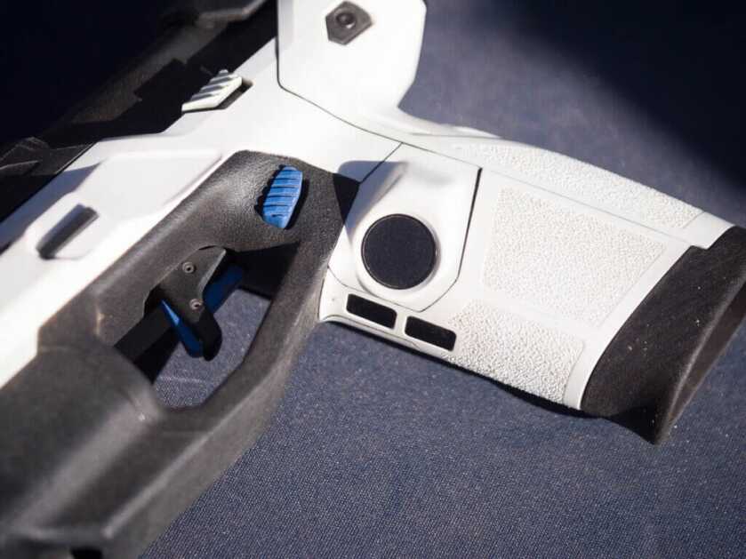 The left side of the pistol grip and trigger guard showing the finger sensor.