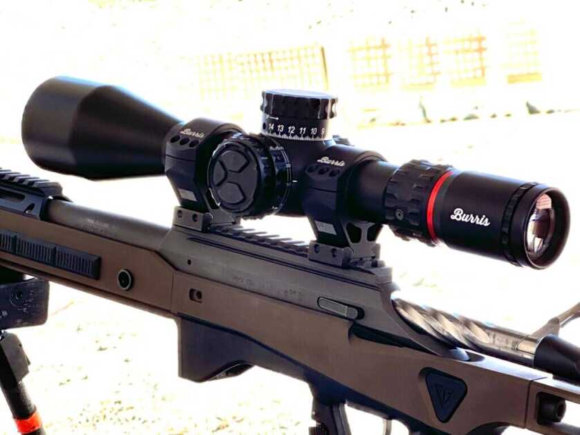 A rifle scope is mounted on top of a bolt action rifle. 