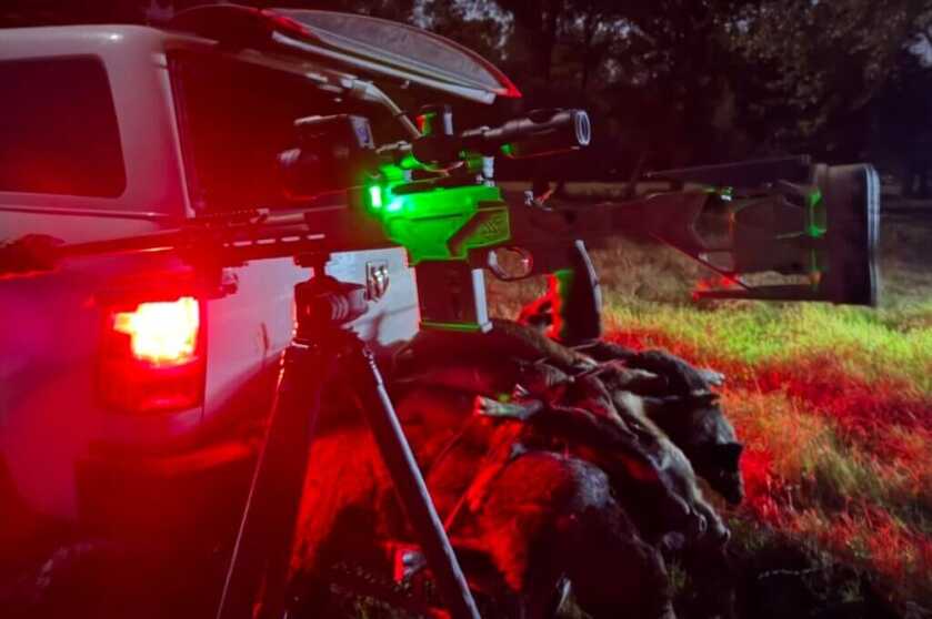 rifle backlit with red glow by truck taillights