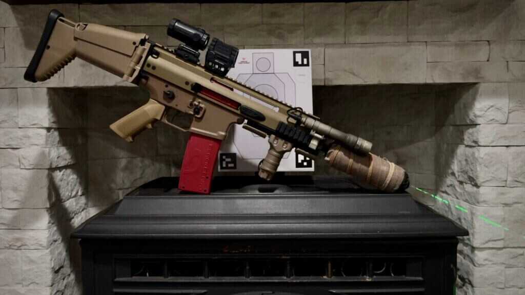 A rifle with BlackbeardX laser training device sits on a stove in front of a target. 