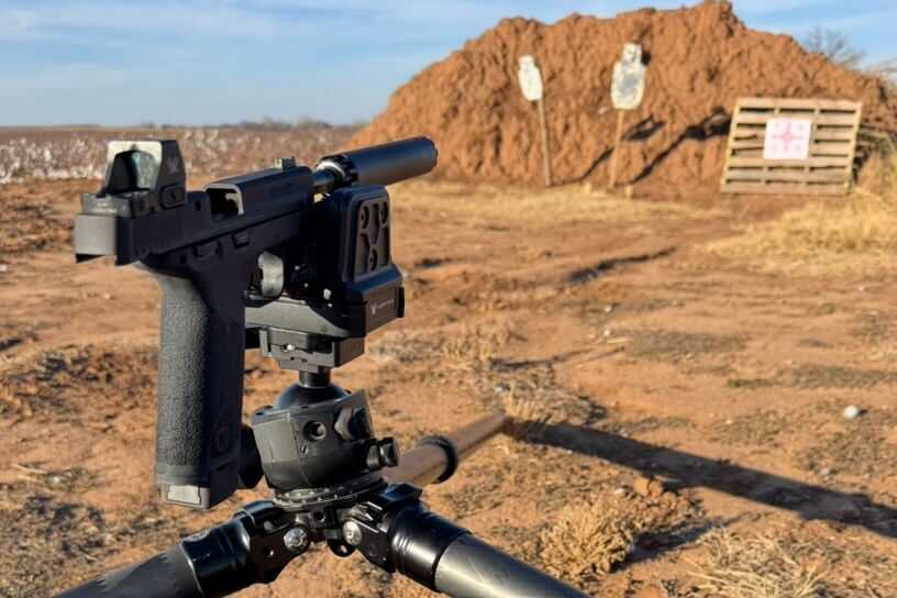 Shooter stabilizing M&P22X on bench to record group sizes and velocities