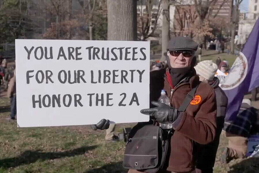 A man holding up a pro-2A sign.