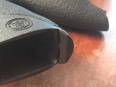 The backstrap removal pin shown in its normal position. To remove, turn 90 degrees and pull it out.