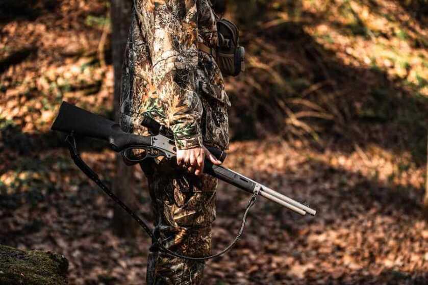 Hunter carrying a Smith & Wesson Model 1854 .45-70 lever action through the woods