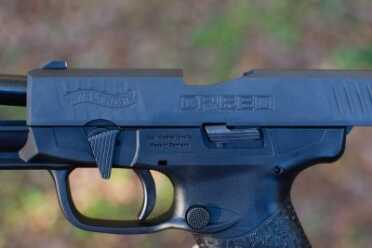 The takedown lever is located forward of the slide stop and above the trigger guard.