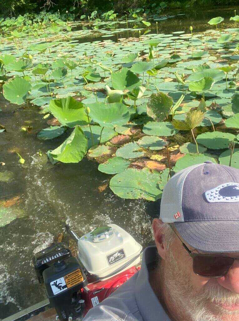 PPF Wood Duck mud motor churning through thick green vegetation on lake surface