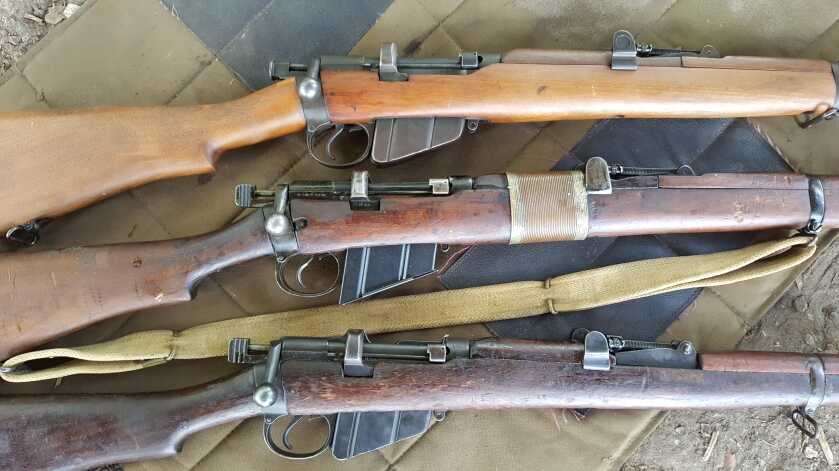 Three Lee-Enfield military surplus rifles on a table