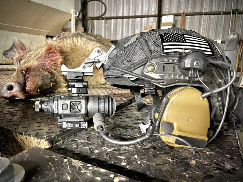 N-Vision NOX18 thermal monocular on a helmet next to a hog taken at night