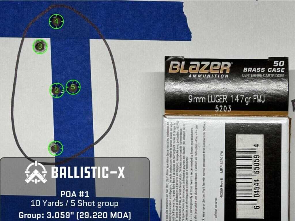 A paper target displays a 5 round group of shots.