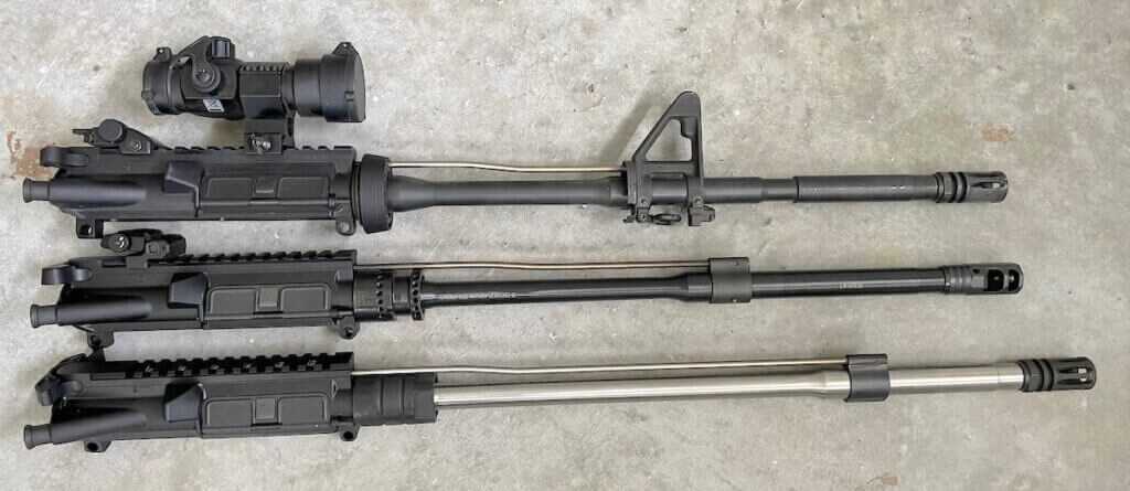 Three AR-15 uppers showing carbine, mid-length and rifle-length gas systems side by side
