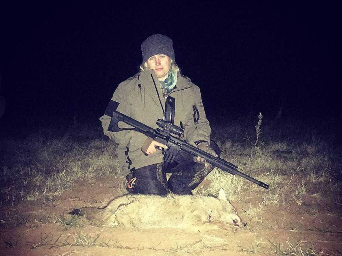 Hunter with a coyote taken with a Bushmaster 450 BM SD semi auto rifle at night