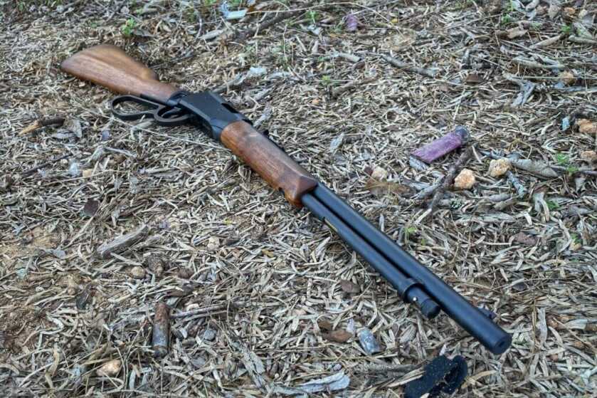 Savage rifle on dried grass and bark