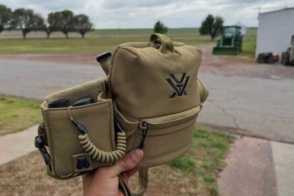 person holding up range bag with gear in it
