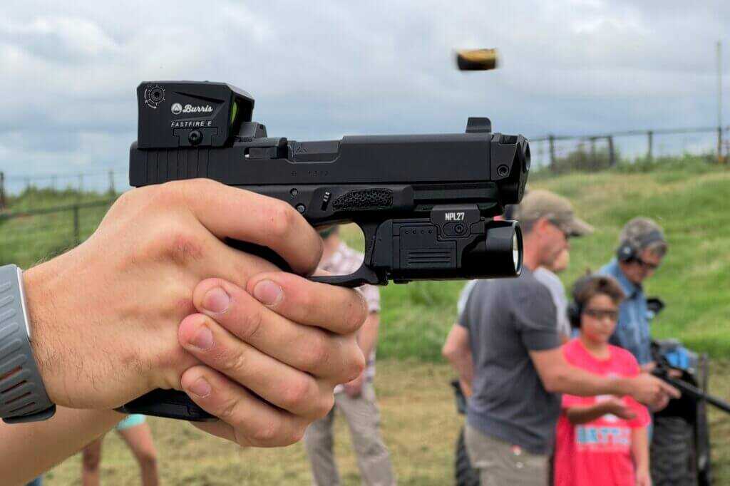 hands holding pistol with red dot