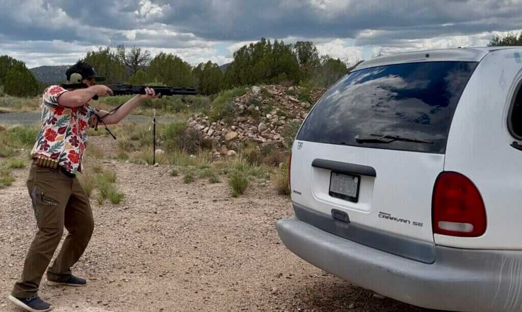 A man in a Hawaiian shirt is shooting the 940 Pro Tactical SPX from beside a van.