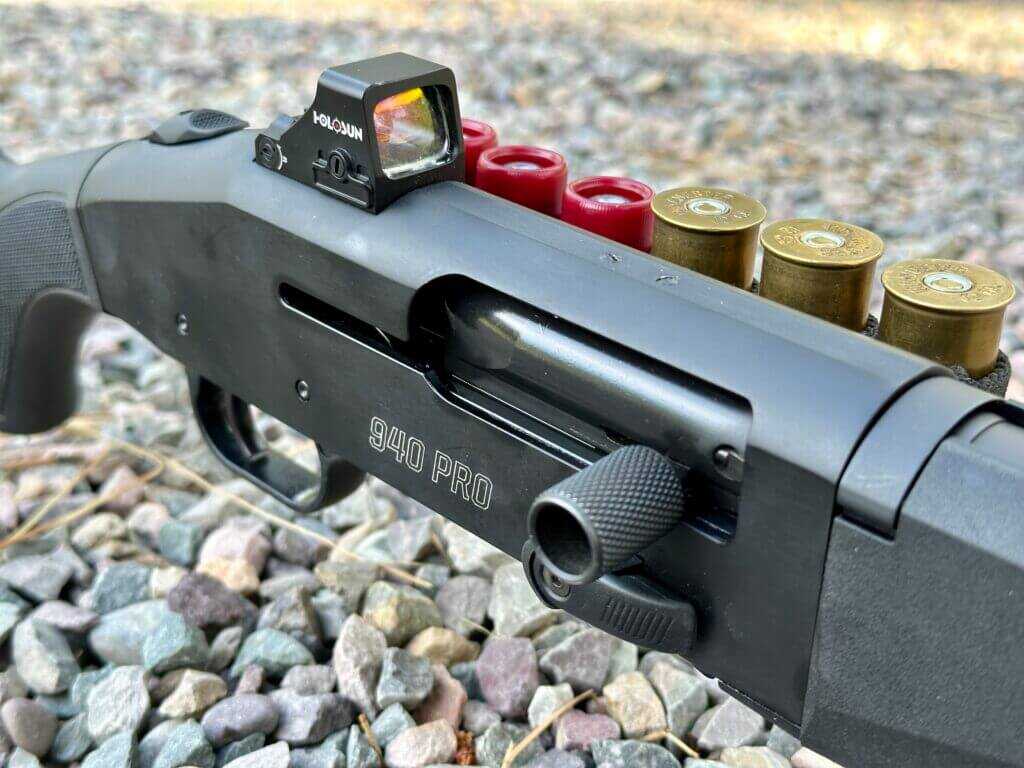 Closeup of a semi-auto shotgun reveiver and a red-dot.