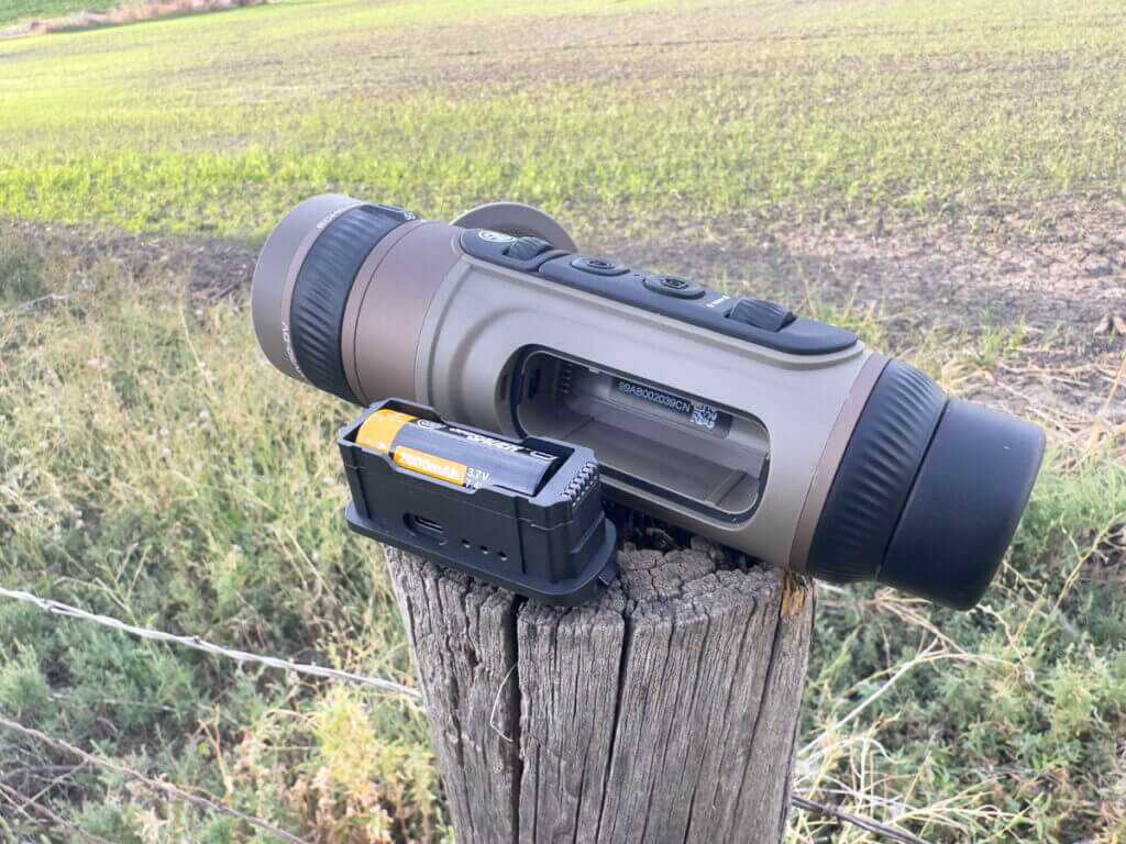 Front objective lens of the SIG Echo MV50-DV showing 25–50mm dual-view design on a fencepost outdoors