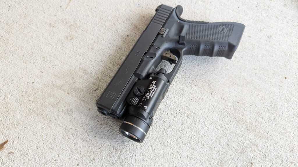 Handgun with weapon-mounted light on dust cover demonstrating standard mounting