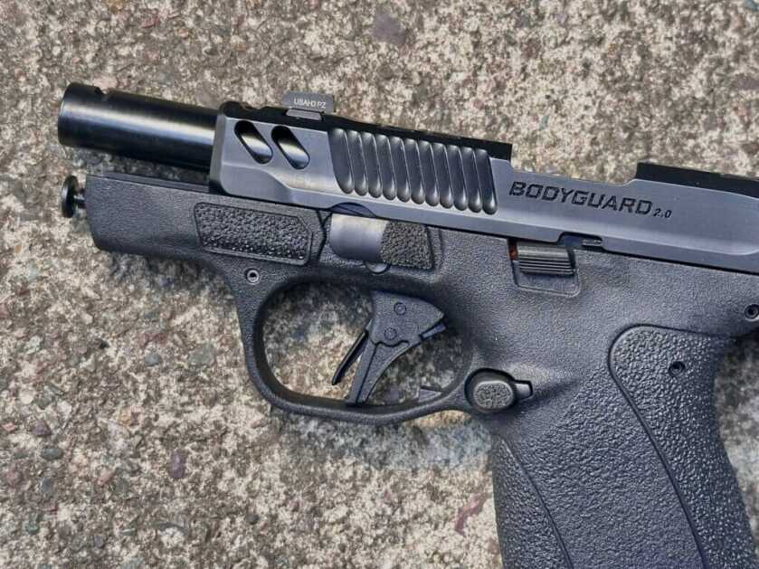 Close view of flat-faced trigger and offset slide stop on S&W Bodyguard 2.0 Carry Comp .380