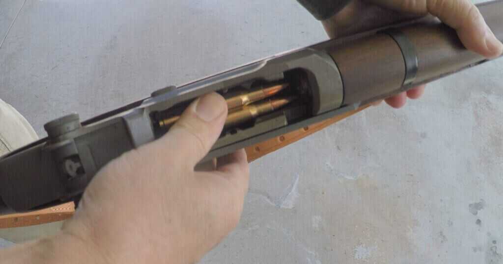 Shooter loading an en bloc clip into an M1 Garand military surplus rifle