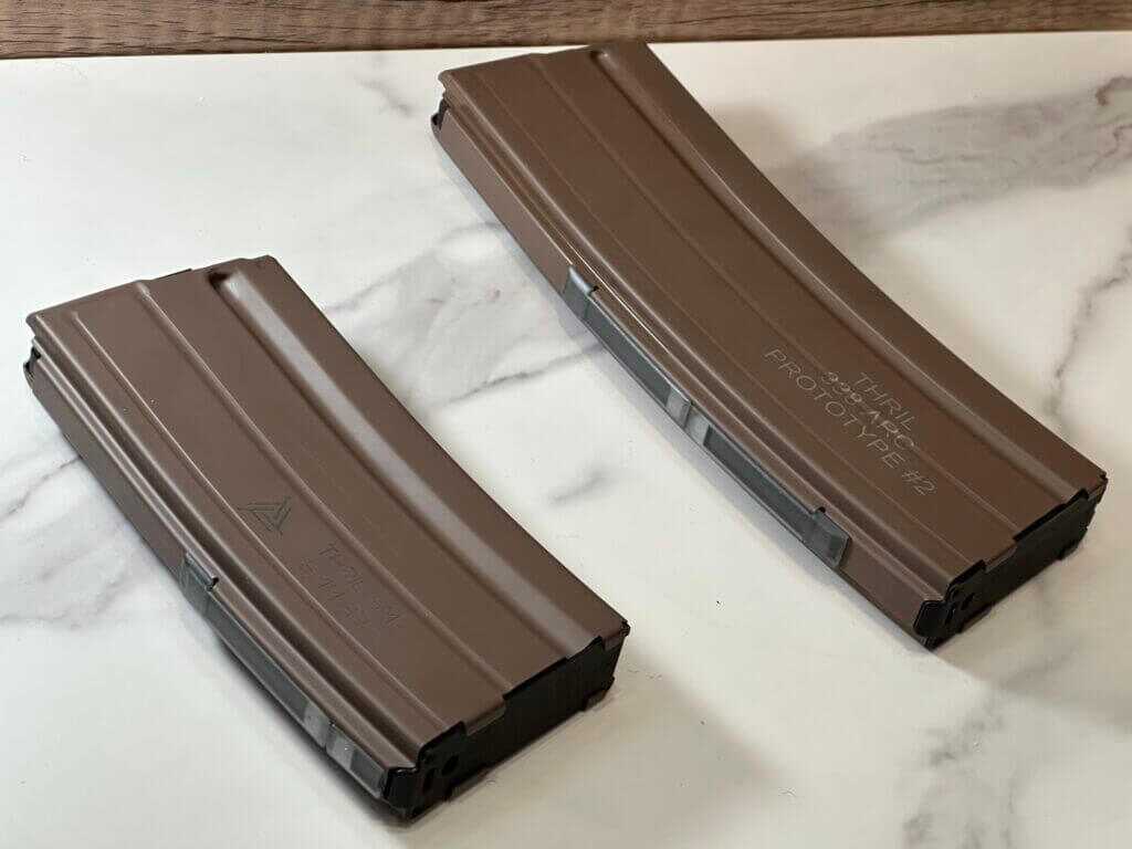 Two tan magaizines lay on a marble table top.