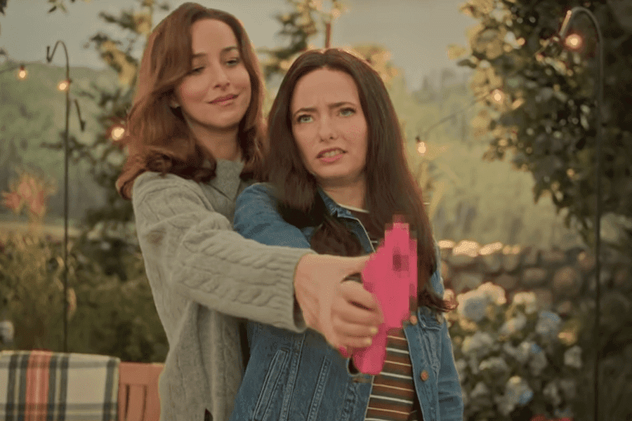 Dakota Johnson demonstrates a blurred pink prop gun during SNL’s “Guns for Women” sketch.