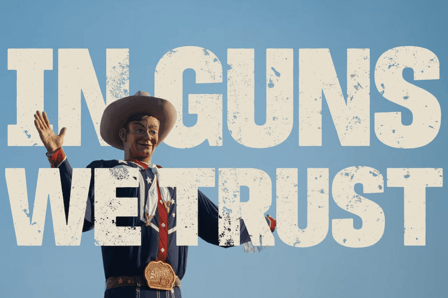 In Guns We Trust documentary title displayed over the Big Tex cowboy statue against a blue sky.