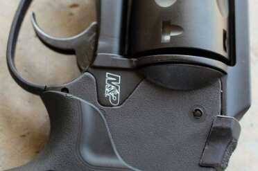 Smith & Wesson M&P .38 Hammerless Revolver w/Crimson Trace To release the cylinder, push the lever below the rear sight forward. It swings out to the left.