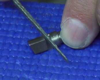 Hand Building a Custom 1911 (The Bob Marvel Way) The author uses a diamond file to reshape part of the extractor.