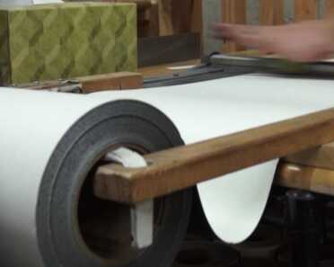 Material from the raw rolls is cut into machine-sized panels for the laser cutters.