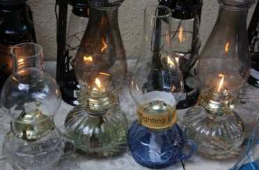 The two lit lanterns are the 7/8ths wick glass found Walmart lanterns. If you search Amazon or Ebay you'll find the glass handle lanterns for under $20 each. 