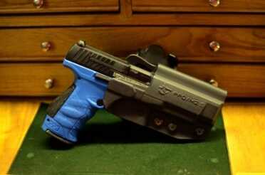 A black gun with an orange tip is hard to judge when it is in a holster.