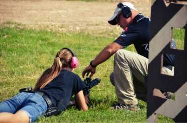 Armalite shooter, Greg Jordan, instructing a young shooter on shooting rifle from prone. 